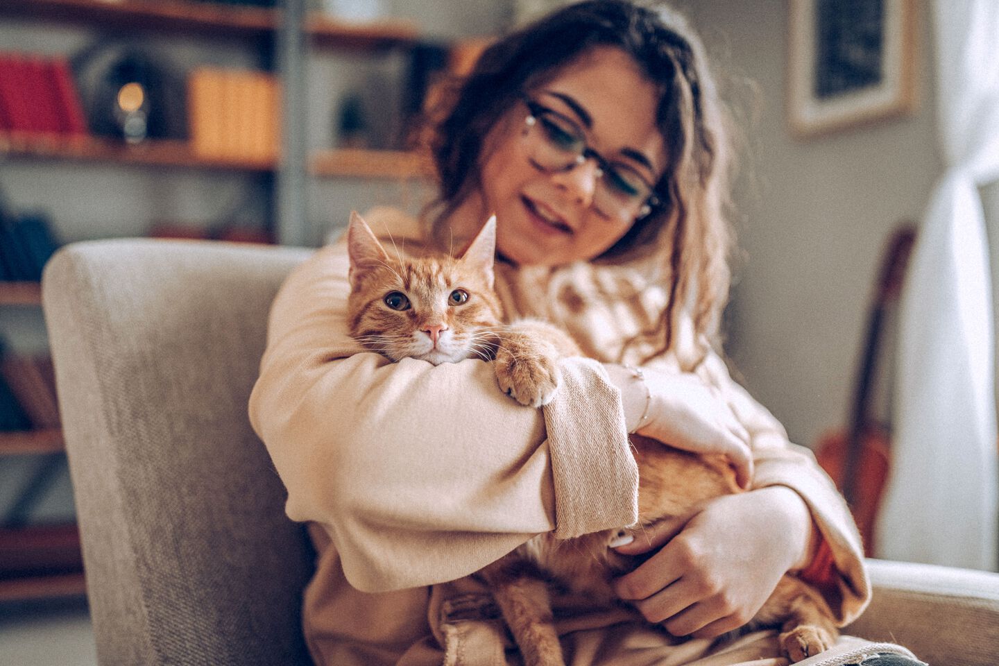 Une fille serre son chat dans ses bras sur le canapé