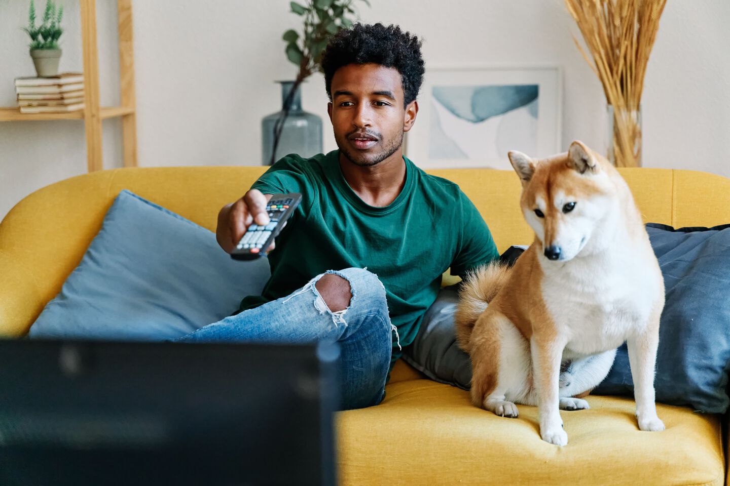 Pet parent con su perro viendo una pel&iacute;cula en casa