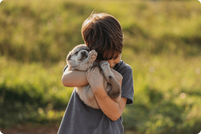 Gar&ccedil;on serrant un chien