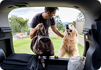 homme tenant une valise et touchant un chien